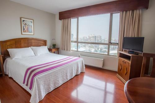 a bedroom with a bed and a television at MR Apart Providencia (ex Apart Neruda) in Santiago