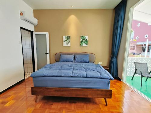 a bedroom with a blue bed in a room at Port Dikson Beach Side Villa in Port Dickson