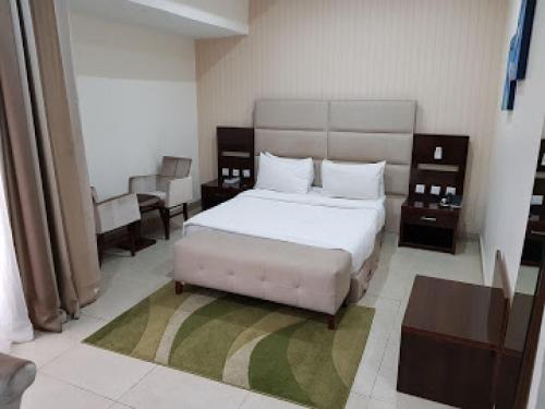 a bedroom with a bed and a table and chairs at Full Moon Hotel - Penthouse in Owerri