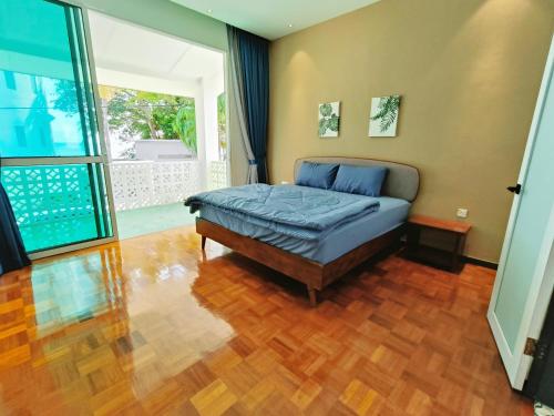 a bedroom with a bed and a wooden floor at Port Dikson Beach Side Villa in Port Dickson
