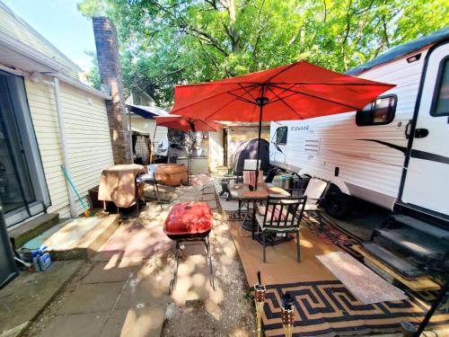 a patio with a red umbrella next to an rv at Plaid Room 3min From Yale Univ in New Haven