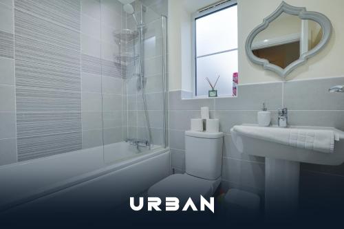 a bathroom with a toilet and a sink and a mirror at Perfect Contractor House 3 Bedroom Sleeps 7 in Peterborough