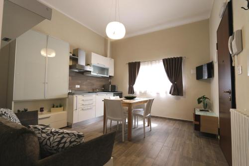 cocina y sala de estar con mesa y sillas en Le Stanze Apartament, en Bolonia