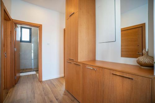 a large wooden cabinet in a room with a door at Charming and beautifully furnished apartment with direct poolside access in Ayios Nikolaos