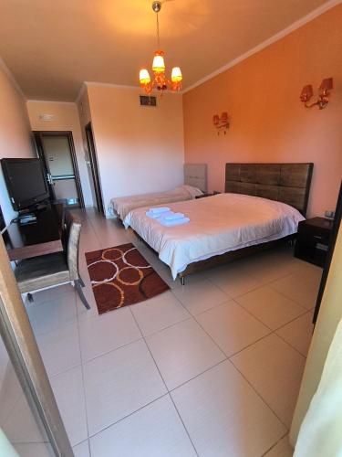 a bedroom with two beds and a television in it at Faraggi Hotel in Simvolí