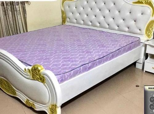 a bed with a purple and white bed frame at Villa Amina splendid elegant structure in Ouagadougou