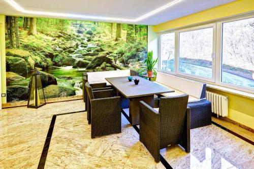 a dining room with a mural of a forest at Hotel Muschinsky in Bad Lauterberg