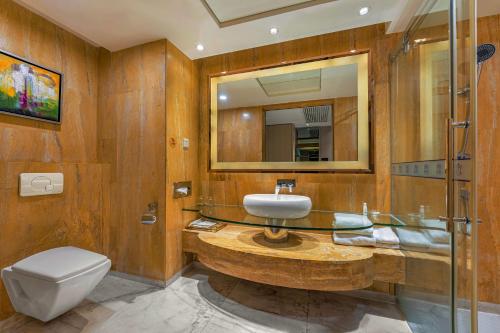a bathroom with a sink and a toilet and a mirror at Meihao Mingyue Hotel International Finance City Keyun Road Metro Branch in Guangzhou