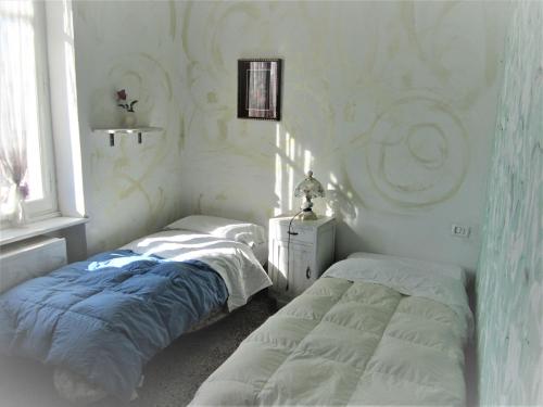 a bedroom with two beds and a window at Casa Di Collina Nelle Langhe Typical country house in Belvedere Langhe