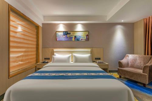 a hotel room with a bed and a chair at Meihao Mingyue Hotel International Finance City Keyun Road Metro Branch in Guangzhou