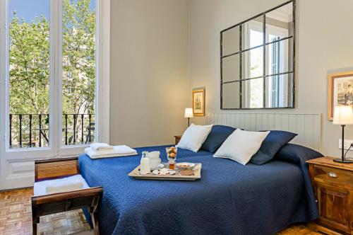 a bedroom with a blue bed with a tray on it at Bcn Paseo De Gracia Rocamora Apartment in Barcelona