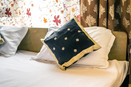 a blanket on a bed with pillows at Grand Aurora Retreat in Srinagar