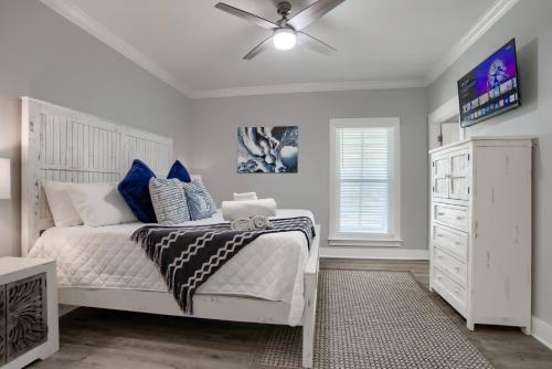 ein Schlafzimmer mit einem weißen Bett und einem Deckenventilator in der Unterkunft 6026 Rookery 3 Deja Blue Beach Cottage With 2 Pools in Gulf Shores