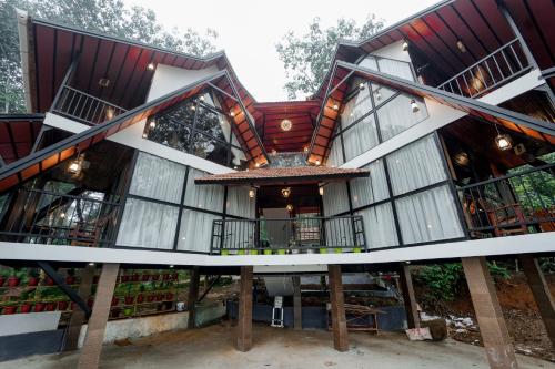 an exterior view of a house with a large building at Wayanad Vista Palm View Homes in Padinjarathara