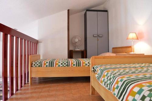 une chambre avec deux lits et un placard dans l'établissement SP320-528 Maison 2 pièces mezzanine SAINT PIERRE LA MER, à Saint Pierre La Mer