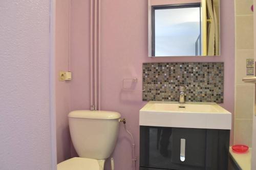 une salle de bains rose avec toilettes et lavabo. dans l'établissement SP320-528 Maison 2 pièces mezzanine SAINT PIERRE LA MER, à Saint Pierre La Mer