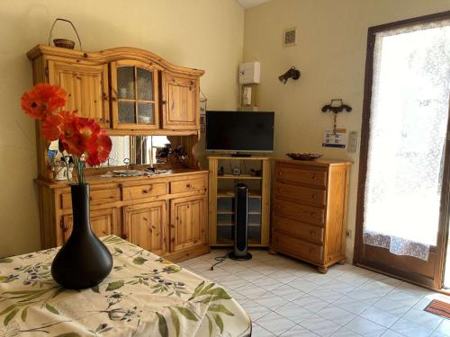 une cuisine avec des placards en bois et un vase avec des fleurs sur une table dans l'établissement SP330-027 Maison SAINT PIERRE LA MER, à Saint Pierre La Mer