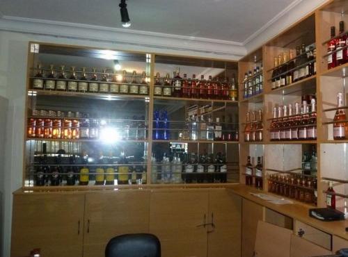a room with a bar with lots of bottles of alcohol at Definite Destiny Hotel - Standard in Asaba
