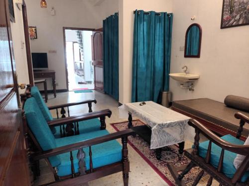 a living room with chairs and a table and a sink at Villa Felicia 1BHk property with Kitchen and Modern Amenities in Puducherry