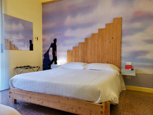 a bedroom with a large bed with a wooden headboard at Red Carpet rooms in Bari