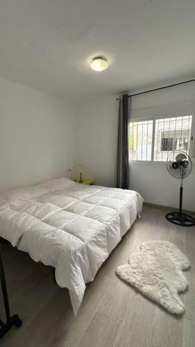 a white bedroom with a large bed and a window at Apartment Almazora II Rental Holidays Ref 036 in Almazora