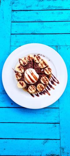 a white plate with a dessert on a blue table at Blue Mango Beach Hotel in Guachaca