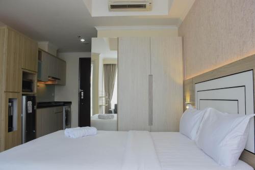 Ένα ή περισσότερα κρεβάτια σε δωμάτιο στο Fully Furnished with Cozy Design Studio at Menteng Park Apartment By Travelio