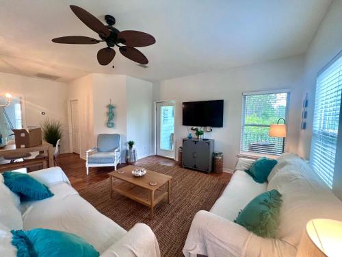 a living room with two white couches and a flat screen tv at 4014 Rookery 3 Cottage with two Pools and Beach Amenities in Gulf Highlands