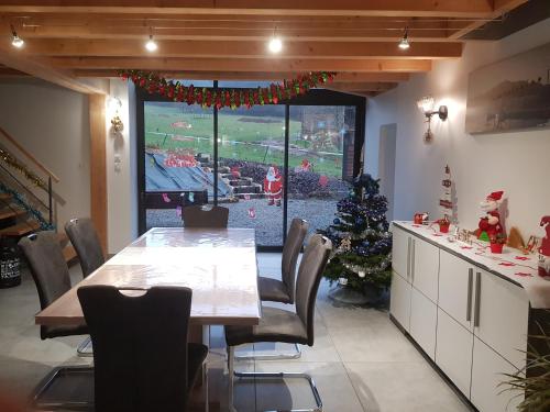 une salle à manger avec une table et un sapin de Noël dans l'établissement Gîte de caractère, à Saint-Jean-la-Vêtre