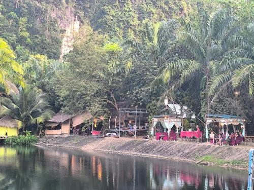 a river with a group of people sitting next to trees at KRABI BAMBOO KINGDOM at AOLUEK PARADISE in Ao Luk