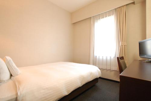 a hotel room with a bed and a window at AB Hotel Mikawa Anjo Minamikan in Anjo