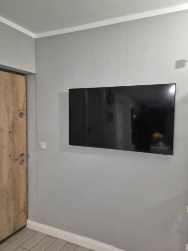 Elle comprend une télévision à écran plat sur un mur blanc. dans l'établissement HUGO Luxury Brand New 2 Bedrooms Apartment in the Center, à Craiova