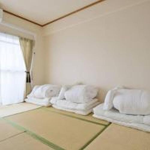 a room with four white pillows and a window at City Heights Shinosaka 703 シティハイツ新大阪 703 in Osaka