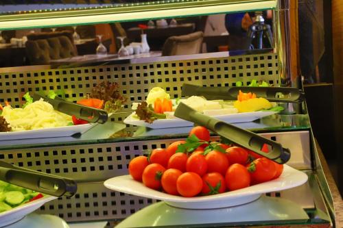 a display case with plates of tomatoes and pasta at Arya Hotel Sakarya in Sakarya