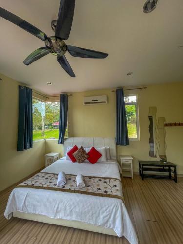 a bedroom with a bed with a ceiling fan at Orchard Villa, Radiant Janda Baik in Bentong