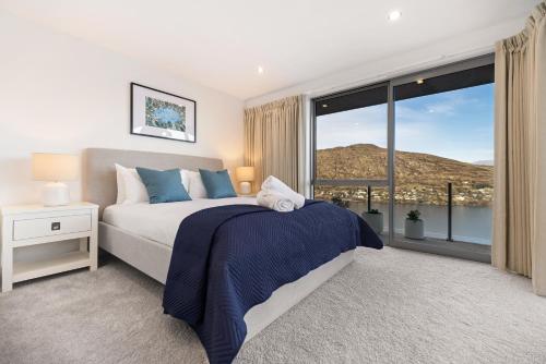 una camera da letto con un letto e una grande finestra di Luxury Away - Aurora Vista a Queenstown