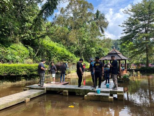 a group of people standing on a dock in the water at Orchard Villa, Radiant Janda Baik in Bentong