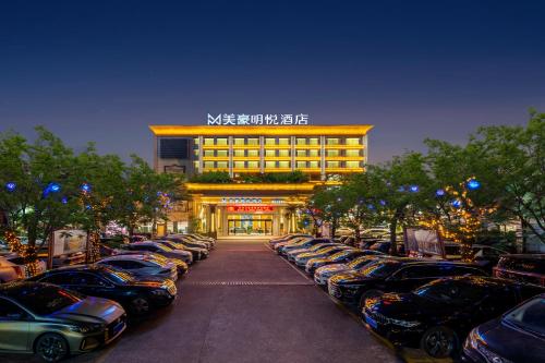 a parking lot with cars parked in front of a building at Meihao Mingyue Hotel International Finance City Keyun Road Metro Branch in Guangzhou