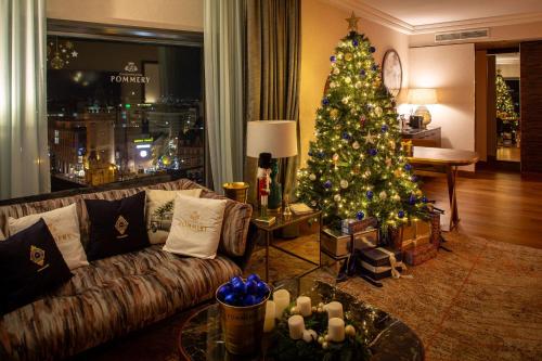 a christmas tree in a living room with a couch at Hilton Frankfurt City Centre in Frankfurt/Main