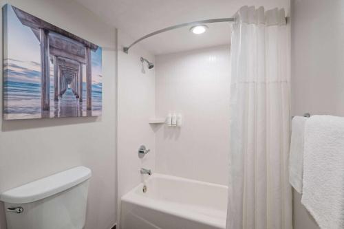 a white bathroom with a shower curtain and a toilet at La Quinta Inn by Wyndham San Diego - Miramar in Sabre Springs