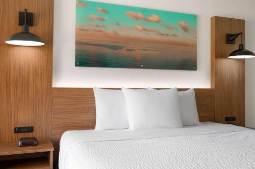 a bedroom with a white bed and two lights at La Quinta Inn by Wyndham San Diego - Miramar in Sabre Springs