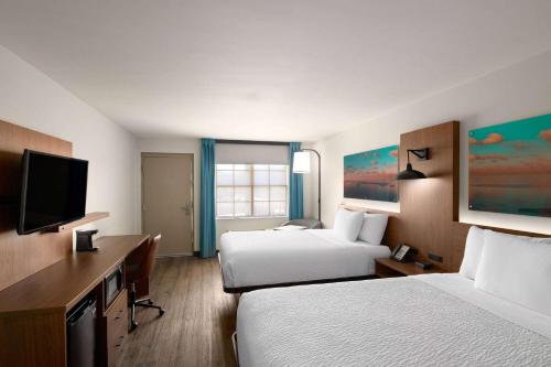 a hotel room with two beds and a flat screen tv at La Quinta Inn by Wyndham San Diego - Miramar in Sabre Springs
