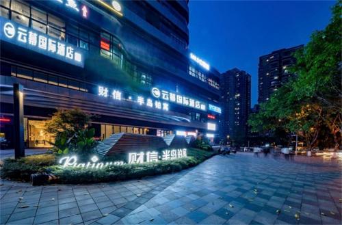重慶市にあるYunmu International Hotel Chongqing Jiefangbei Pedestrian Street Branchの夜に看板が立っている建物