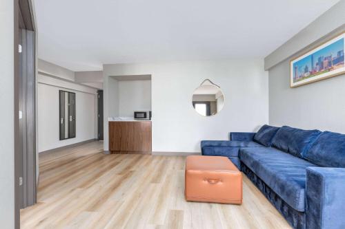 a living room with a blue couch and a table at La Quinta by Wyndham Dallas DFW Airport North in Irving