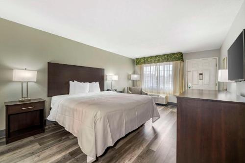 a hotel room with a large bed and a desk at Quality Inn Siloam Springs West in Siloam Springs