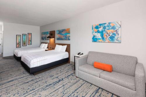 a hotel room with a bed and a couch at La Quinta by Wyndham Rockport - Fulton in Rockport