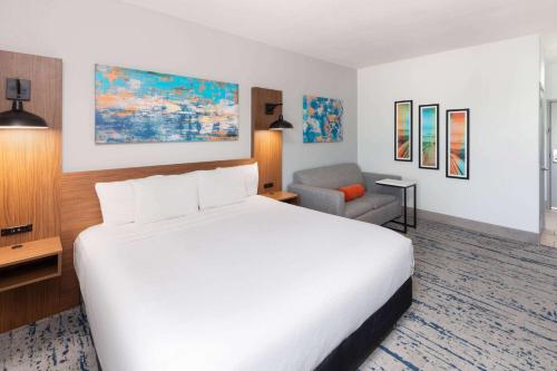 a hotel room with a large bed and a chair at La Quinta by Wyndham Rockport - Fulton in Rockport