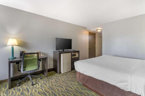 a hotel room with a bed and a desk with a television at Clarion Inn near Lookout Mountain in Chattanooga