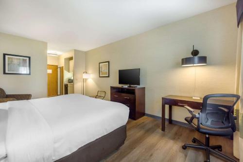 a hotel room with a bed and a desk with a computer at Comfort Inn Federal Way - Seattle in Federal Way