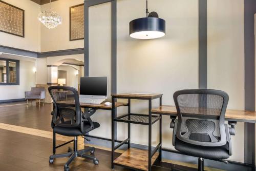 an office with a desk and two chairs and a laptop at Comfort Inn Federal Way - Seattle in Federal Way